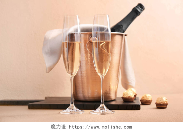 香槟色背景上的高脚杯和装香槟的桶有冰块和香槟的篮子，背景是彩色的